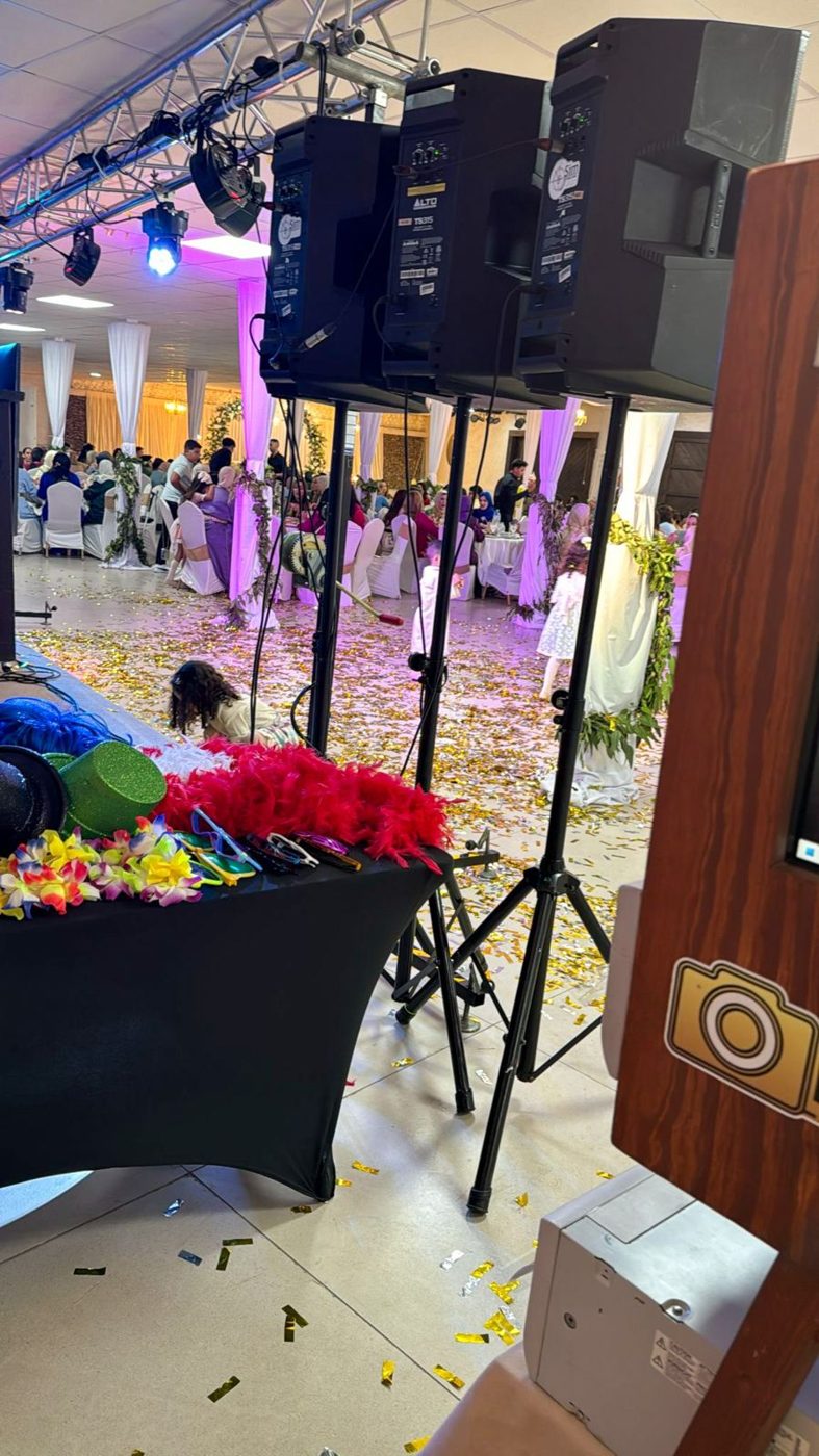 Mesa de atrezo junto al fotomatón en un salón de bodas lleno de confeti