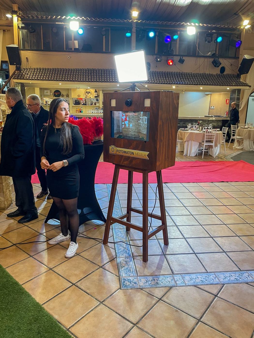 Invitada junto al fotomatón en un salón